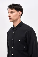 Camisa de corte regular fit confeccionada en algodón, con cuello solapa clásico, cierre frontal con botones y dos bolsillos frontales en el pecho.