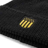 Gorro de lana tejido en color negro con vuelta, presenta un parche frontal con el escudo del Club Atlético Peñarol y el logo de la marca Puma bordado en el lateral.