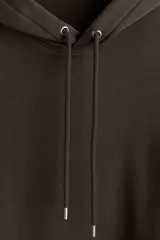 Canguro de corte holgado con capucha forrada y cordón de ajuste. Presenta hombros caídos, bolsillo frontal tipo canguro y terminaciones acanaladas en puños y ruedo. Confeccionado en mezcla de algodón con interior suave.