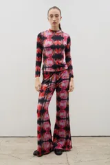 Pantalón de corte recto y tiro alto, confeccionado en tela sublimada con estampado abstracto en tonos rojos, rosas y negros.