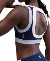 Top deportivo azul marino con contorno blanco y detalles en lila, de calce ajustado y breteles anchos.