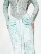 Set compuesto por body semitransparente de manga larga con escote en V y cuello camisero, y pollera larga al cuerpo con frunce y lazo delantero, con estampado animal print en tonos aqua.