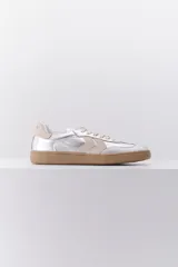 Zapatillas plateadas de cuero con suela marrón y detalles en beige.