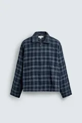 Camisa boxy fit de cuadros en tonos azules y negros, confeccionada en tejido con mezcla de algodón. Cuenta con cuello solapa, manga larga y cierre frontal con cremallera.