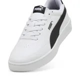 Championes Puma modelo Court Classic Clean, de diseño urbano en color blanco con la icónica franja lateral en negro. Presenta una silueta de perfil bajo con suela de goma resistente y detalles de la marca en la lengüeta y el talón.