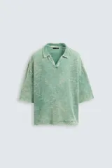 Polo de punto de algodón, color verde menta con efecto lavado que le da un aspecto desgastado y texturizado. Presenta un corte relajado (relaxed fit), cuello solapa con abertura frontal en V y mangas cortas.