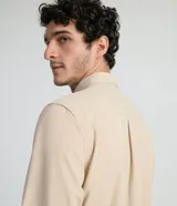 Camisa de manga larga color beige, con cuello camisero y dos bolsillos frontales con cierre en solapa.