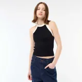 Top de punto negro con cuello halter y ribetes blancos en contraste, corte al cuerpo y diseño sin mangas.