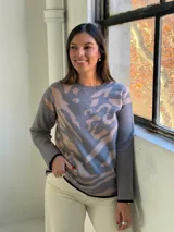Sweater de punto con diseño estampado abstracto en tonos gris y beige, cuello redondo y terminaciones en color negro.