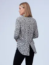 Camisa estampada blanca y negra con cuello clásico, abertura frontal con botones ocultos y mangas largas con puños abotonados.