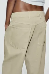 Jeans de tiro medio y corte barrel con diseño de perneras curvadas, tiro medio, trabillas para cinturón y cinco bolsillos. Presenta lavado clásico y costuras pespunteadas decorativas en la parte delantera.
