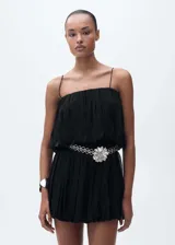 Vestido corto negro de estilo globo, confeccionado en viscosa con forro de poliéster. Presenta tirantes finos, escote recto fruncido y diseño holgado con frunces en la cintura.