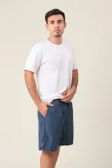 Bermuda deportiva de nylon color gris, de corte suelto, con cintura elástica y cordón de ajuste. Cuenta con detalles de líneas negras en los costados y bolsillos laterales con cierre.