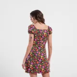 Vestido corto color beige con estampado de cebra en negro, escote cuadrado con lazo ajustable y mangas cortas.