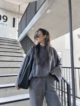 Buzo deportivo gris nevado con costuras externas y tela elastizada.