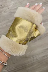 Guantes mitones de cuero ovino en color dorado, con interior de lana natural peinada y bordes de corderito en tono beige.