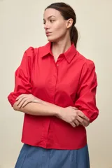 Camisa de algodón color rojo con cuello camisero, frente abotonado y mangas largas abullonadas de calce relajado.