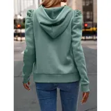 Buzo tipo hoodie de color azul marino, confeccionado en tejido suave con diseño de mangas princesa fruncidas en los hombros. Presenta capucha con cordones ajustables y puños elásticos.