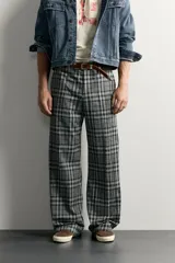 Pantalón flare fit confeccionado en tejido con algodón, con estampado a cuadros en tonos grises y negros. Cuenta con bolsillos laterales, bolsillos traseros de vivo y cierre frontal con cremallera y botón.