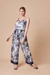 Pantalón palazzo estampado en tonos blanco y azul, con cintura elastizada y cordón ajustable.