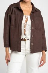 Sobrecamisa de gamuza sintética en color marrón chocolate, con corte oversize, cuello camisero, cierre frontal con botones y bolsillos frontales tipo parche.