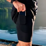 Short de compresión deportivo tipo biker para hombre, de color negro, con paneles de malla y un bolsillo lateral diseñado para guardar el teléfono celular.