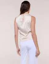 Blusa de satén color negro, de corte fluido, con escote asimétrico y un aro metálico decorativo en el hombro.
