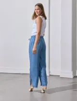 Pantalón celeste de lyocell, corte ancho, con pretina elastizada con lazo de ajuste, bolsillos verticales y ruedo desflecado.