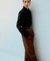 Pantalón de corte wide leg, confeccionado en material sintético efecto cuero color marrón, con pinzas en la cintura y bolsillos laterales.