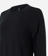 Suéter negro de punto leve, corte boxy, cuello redondo y mangas largas con puños y bajo acanalados.