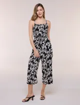 Enterito crop de rayón con estampado geométrico en blanco y negro, busto elastizado con frunces, breteles finos regulables y cordón ajustable en la cintura con terminaciones de borlas. Pantalón de corte amplio y relajado.