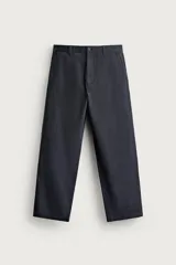 Pantalón chino regular fit confeccionado en algodón, color negro, con bolsillos frontales, bolsillos traseros de vivo con botón y cierre frontal con cremallera y botón. Colección especial Aaron Levine x ZARA.