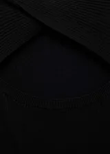 Vestido midi de punto acanalado, con diseño entallado, cuello redondo y mangas cortas. Presenta una abertura frontal y un diseño reversible.