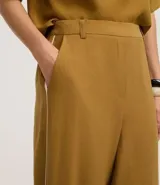 Pantalón wide leg de viscosa color ocre, con cintura elástica, trabillas y rayas laterales blancas.