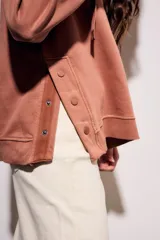 Sweater con capucha color negro, con cordones ajustables y botones en el escote.