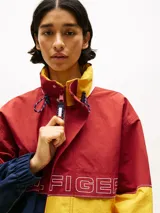 Campera de nailon con diseño color block en rojo, amarillo y azul marino. Tiene cuello alto, cierre de cremallera oculto con botones a presión, puños y bajo elásticos, dos bolsillos ribeteados en la cintura y logo de Tommy Hilfiger en la parte delantera, la trasera y las mangas.