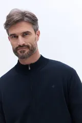 Campera de tejido de punto liviano color beige, con cierre frontal completo y cuello alto tipo bomber. Presenta un pequeño logo bordado en el pecho y puños acanalados.