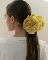 Pinza para el pelo con diseño de flores blancas grandes estilo clavel, con mecanismo de agarre tipo clip en tono beige.