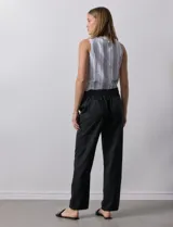 Pantalón de corte recto confeccionado en mezcla de lino, color verde claro. Presenta una pretina ancha con lazo de ajuste frontal y bolsillos laterales verticales.