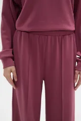 Pantalon de corte ancho y tiro medio, confeccionado en tejido de poliester, con cintura elastizada y costura central vertical en el frente.