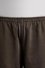 Pantalón jogger de corte relajado confeccionado en tejido compacto de algodón. Presenta cintura elástica con cordón interior, bolsillos frontales en la cadera y un bolsillo trasero de plastrón.