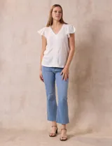 Blusa celeste en tejido pointelle con escote en V y mangas cortas con volados. Aplique de puntilla en el escote y en el frente.