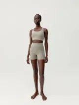 Short deportivo color beige, de tejido Shape_Tech, con tecnología performance. Diseño sin cinturilla, costuras termoselladas y cinta reflectante decorativa.