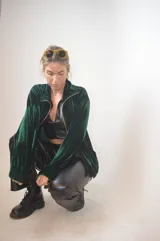 Campera verde inglés de terciopelo con cierre dorado y cuello alto.