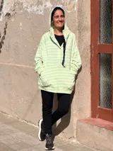Canguro oversize de rústico de algodón con diseño a rayas horizontales en color verde menta y blanco. Presenta capucha, escote con broches frontales, bolsillo tipo canguro al frente y puños elásticos en mangas y ruedo.