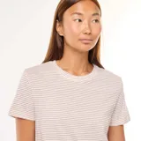 Conjunto de pijama de dos piezas, compuesto por una remera de manga corta y un pantalón largo, ambos a rayas horizontales en tonos beige y blanco.