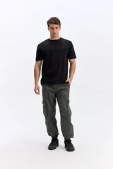 Pantalón cargo color tostado de corte amplio, con cintura elástica y cordón ajustable. Cuenta con bolsillos laterales con tapa en las piernas y puños elastizados en los tobillos.