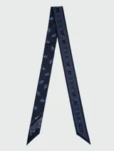 Pañuelo tipo bandana de seda, color amarillo con estampado gráfico y letras en negro. Diseño cuadrado con bordes definidos.