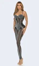 Body entero de corte ajustado confeccionado en tejido mesh transparente. Presenta un diseño con copas estructuradas y aplicaciones de pedrería brillante distribuidas estratégicamente a lo largo de la prenda, creando un efecto visual lineal y sofisticado.