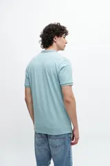 Remera polo azul marino con cuello clásico, tapeta de dos botones y mangas cortas. Presenta un diseño de líneas horizontales texturizadas en la parte superior del pecho y logo bordado en el lateral.